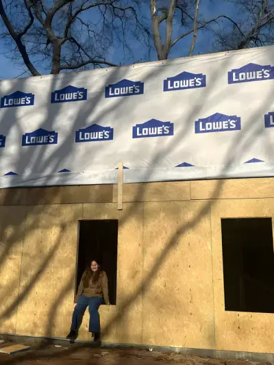 Sheathed exterior wall section under construction beside the main house